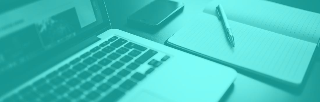 Close-up of Laptop with notebook, pen, and smartphone