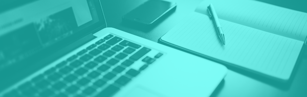 Close-up of Laptop with notebook, pen, and smartphone